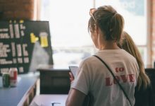 woman in white t-shirt looking at the window during daytime