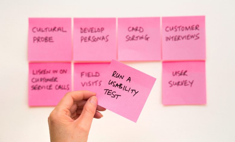 person holding pink sticky note