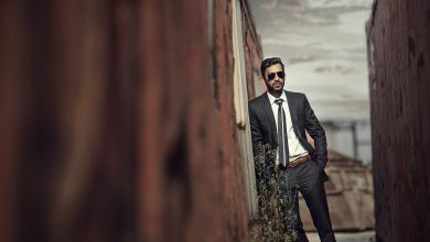 man in black suit standing on brown wooden bridge during daytime