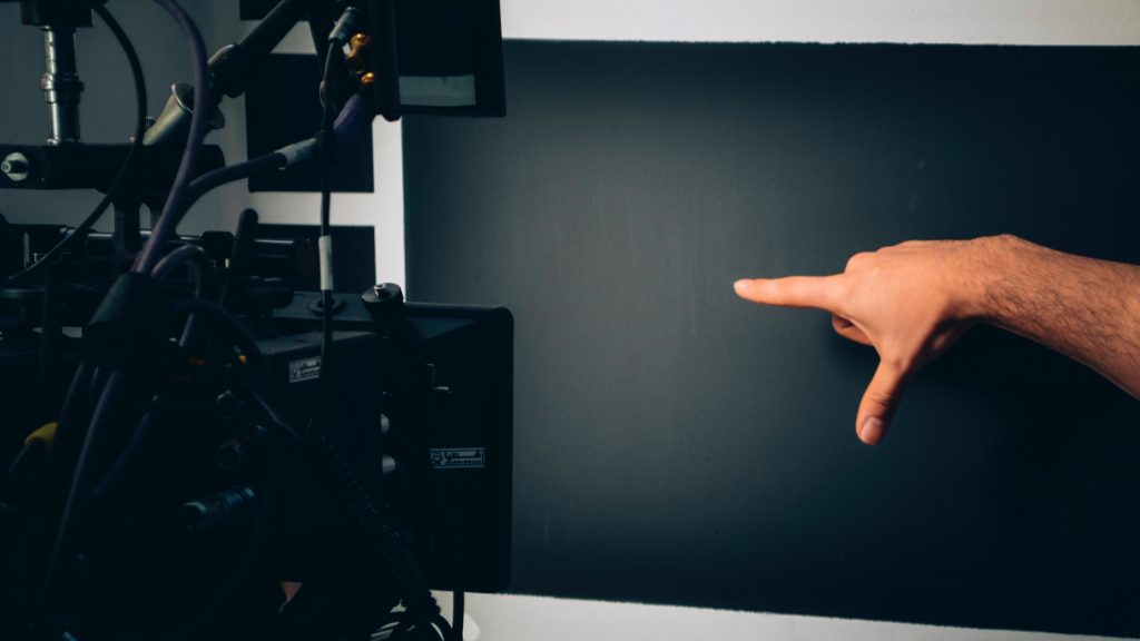 person lying on bed near black flat screen tv