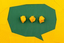 three crumpled yellow papers on green surface surrounded by yellow lined papers