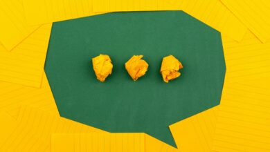 three crumpled yellow papers on green surface surrounded by yellow lined papers