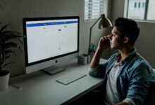 man in blue denim jacket facing turned on monitor