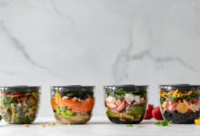 four clear plastic bowls with vegetables