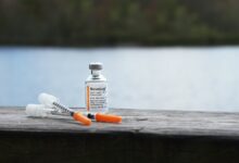 orange and white plastic bottle on brown wooden table
