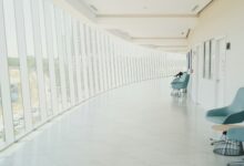 A long hallway with a row of chairs next to a wall
