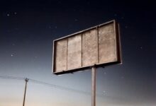 a sign in the middle of a field at night