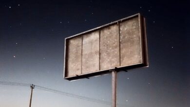 a sign in the middle of a field at night