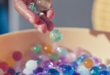 person holding pink yellow and silver beads