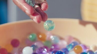 person holding pink yellow and silver beads