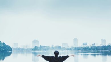 man in black jacket standing near body of water during daytime