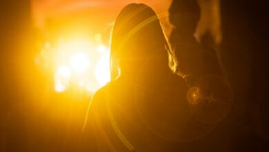 silhouette photography of woman in front of orange light