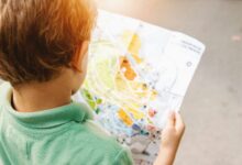 boy standing while reading map