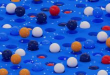 a group of balloons floating on top of a blue surface