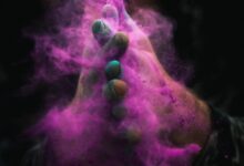person with colored powders on hands
