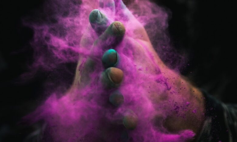 person with colored powders on hands