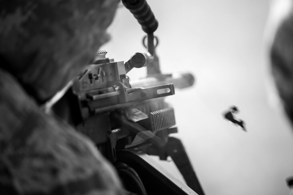 A soldier fires a machine gun.