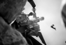 A soldier fires a machine gun.