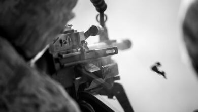 A soldier fires a machine gun.