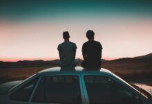two men sitting on vehicle